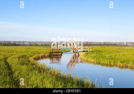 Kleine hölzerne offene Brücke über den niederländischen Kanal Stockfoto