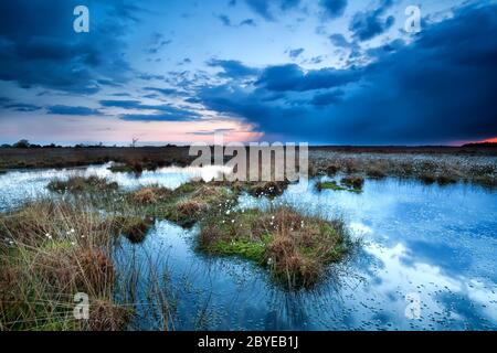 Gewitterwolken über dem See bei Sonnenuntergang Stockfoto