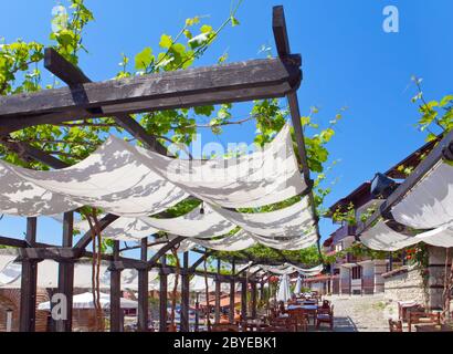 Open-Air-Café auf umwindendem grünen Terrasse. Stockfoto