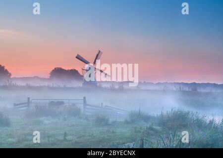 Holländische Windmühle im dichten Morgennebel Stockfoto