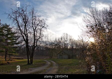 Rustikale Holzhütte aus Baumstämmen in der Landschaft mit Wolken im Hintergrund Stockfoto