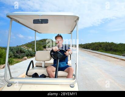 Mann mit dem Golfauto am Meer. Mexiko. Frauen Stockfoto