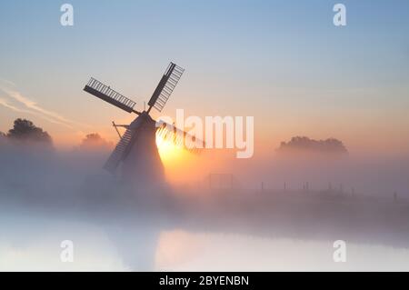 Niederländische Windmühle im dichten Nebel Stockfoto