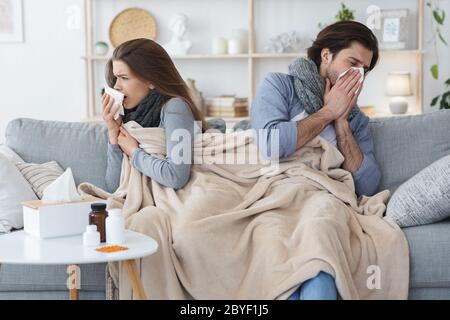 Junges Paar mit Grippe, zu Hause sitzen Stockfoto
