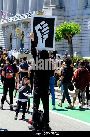Junge, der auf ein erhabene Faust-Poster am San Francisco, Kalifornien-Denkmal schaut und für den Tod von George Floyd am 9. Juni 2020 protestiert; Sinn machen. Stockfoto