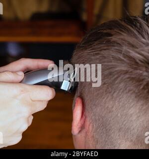 Rasieren Sie die Haare mit einem Trimmer beim Friseur. Stockfoto