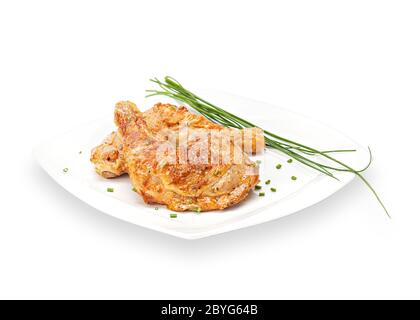 Hot Fried Spicy Chicken ohne Knochen Schlagstock in Teig auf einem weißen Teller mit Schnittlauch. Frittiertes Fleisch aus Hühnerbeinen. Isoliert auf weißem Hintergrund Stockfoto