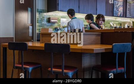 Barista hinter dem Tresen in einem Starbucks Coffee House Outlet, Tokio, Japan Stockfoto