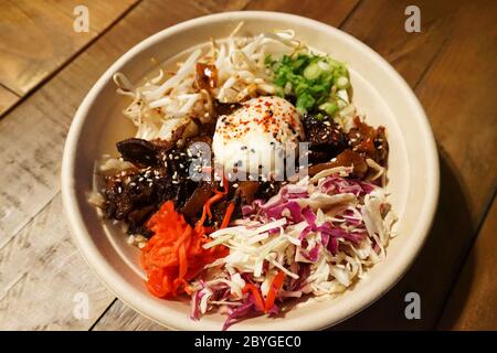 Nahaufnahme Schüssel mit Grill gezogen Rindfleisch auf Reis mit gemischtem Gemüse in koreanischer Stil Stockfoto