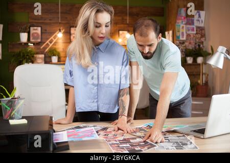 Junge Männer und Frauen Modedesigner auf der Suche nach Inspiration, um eine neue Linie von Kleidern zu machen. Stockfoto