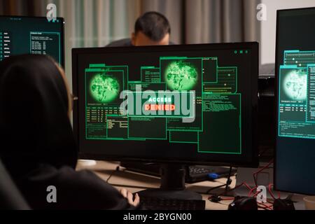 Rückansicht von weiblichen Hackerinnen erhalten Zugriff verweigert, während versucht, eine Firewall zu brechen. Stockfoto