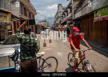 23. Mai 2020, San Pedro Sula, Honduras: Ein Mann, der vorbeugend eine Gesichtsmaske trägt, fährt mit dem Fahrrad durch einen verlassenen Marktplatz. Honduras hat eine "intelligente Wiedereröffnung" eingeführt, die es allen kommerziellen Unternehmen erlaubt, sich zu öffnen, aber alle Mitarbeiter und Kunden dazu auffordert, Masken zu tragen. (Bild: © Seth Sidney Berry/SOPA Images via ZUMA Wire) Stockfoto
