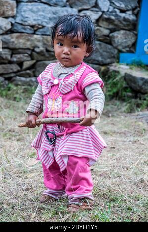 Nepal. Island Peak Trek. In der Sherpa Siedlung von Phakding mit einem kleinen Mädchen in leuchtend rosa Kleidung Stockfoto