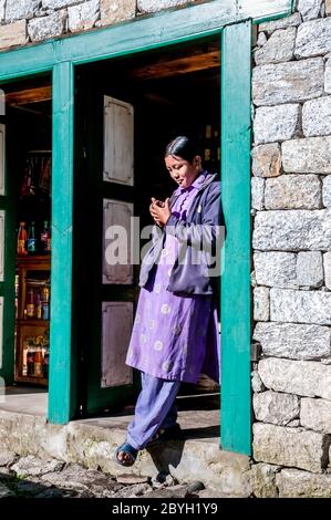 Nepal. Island Peak Trek. Ein junges Sherpa-Mädchen steht vor ihrem Familiengeschäft in der Sherpa-Siedlung Phakding Stockfoto