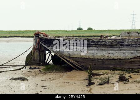 Verderbtes Boot bei Ebbe. Oare Creek, Faversham, Kent, Großbritannien Stockfoto