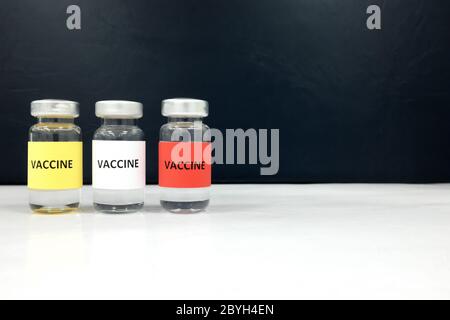Impfstofffläschchen in mehreren Farben mit Kopierfläche. Coronavirus Covid-19 Impfstoffkandidaten Konzept. Stockfoto