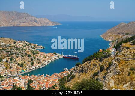 Panoramablick auf das malerische Dorf und den Hafen Gialos auf der griechischen Insel Symi, Dodekanes, Griechenland Stockfoto