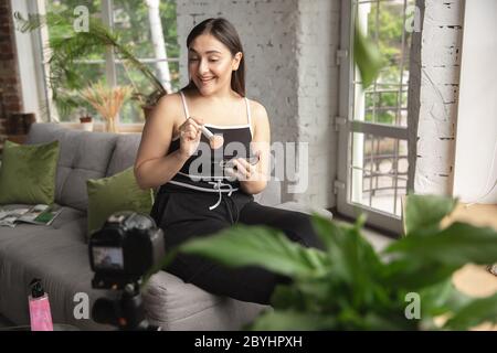 Make-up. Kaukasische Bloggerin Frau machen vlog, wie man Körper positiv und unter Schönheitsbehandlung. Lifestyle, Influencer Frauen, gesundes Konzept. Mit der Kamera, Aufnahme ihrer Kosmetik-Test, Tutorials. Stockfoto