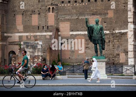 Italien Wiedereröffnung, Start Phase 3. Personen, die eine Schutzmaske tragen, gehen am Dienstag, den 02. Juni 2020 in Rom in der Straße Fori Imperiali nahe dem Kolosseum (Colosseo) umher. Stockfoto