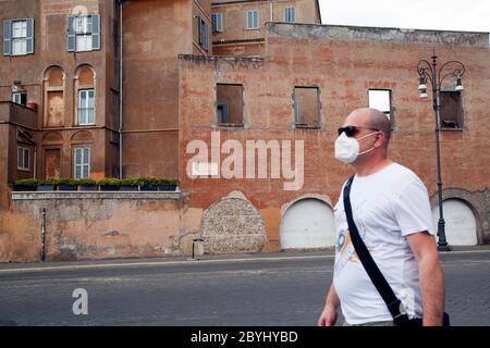 Italien Wiedereröffnung, Start Phase 3. Personen, die eine Schutzmaske tragen, gehen am Dienstag, den 02. Juni 2020 in Rom in der Straße Fori Imperiali nahe dem Kolosseum (Colosseo) umher. Stockfoto