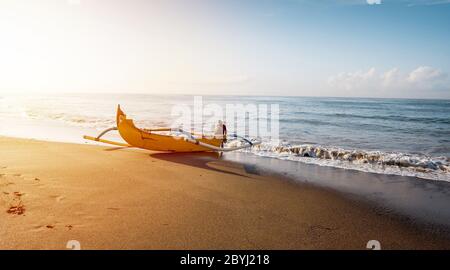 Fischerboot. Landschaft bei Sonnenaufgang. Traditionelle balinesische Bootsanlegestelle. Fischerboot am Strand. Wasserspiegelung. Sanur Beach, Bali, Indonesien. Stockfoto