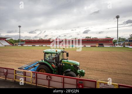 Traktor auf Fußball / Fußballplatz auf Sportplatz während der Saisonende Arbeit von Bodenpersonal Umlagerung Rasen. Stockfoto