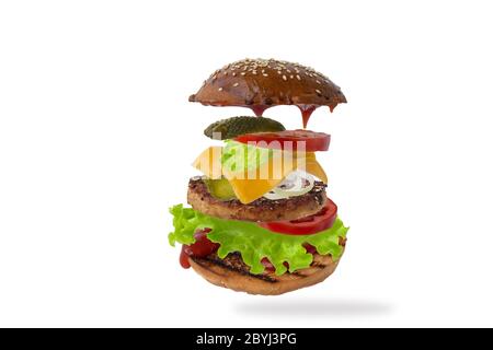 Köstlicher Burger mit fliegenden Zutaten isoliert auf weißem Hintergrund. Konzept der Levitation von Lebensmitteln. Stockfoto