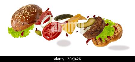 Köstlicher Burger mit fliegenden Zutaten isoliert auf weißem Hintergrund. Konzept der Levitation von Lebensmitteln. Stockfoto