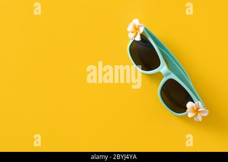 Sonnenbrille mit Blumen auf gelbem Hintergrund Stockfoto