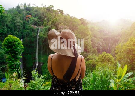 Bild einer jungen Frau mit Hut in einem Dschungel bei Sonnenaufgang. Erfasst auf Wanderwegen in der Nähe des Sekumpul Wasserfalls in Bali, Indonesien. Stockfoto