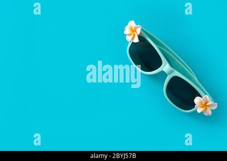 Sonnenbrille mit Blumen auf blauem Hintergrund Stockfoto