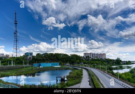 Panoramablick auf Irkutsk Stadt, kleiner Teich mit Reflexion, TV-Turm und Straße von der akademischen Brücke in sonnigen Sommertag mit schönen Wolken Stockfoto