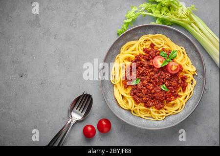 Pasta Spaghetti Bolognese in grauer Schüssel auf Beton Hintergrund. Bolognese Sauce ist klassische italienische Küche Gericht. Beliebte italienische Küche. Stockfoto