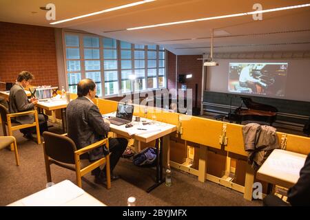 Freiburg Im Breisgau, Deutschland. Juni 2020. Prof. Gilead Mishory (l-r) und Prof. Christoph Sischka hören den Kandidaten Xingjian Xie, der über Skype verbunden ist und das Klavier im Prüfungsraum über eine zweite Verbindung betreibt. Da koronabedingte Reisebeschränkungen derzeit internationale Bewerber erschweren, dürfen Klavieranwärter der Hochschule für Musik in Freiburg erstmals ferngesteuert Klavier spielen. Quelle: Philipp von Ditfurth/dpa/Alamy Live News Stockfoto