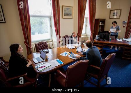 Hinter den Kulissen von Stormont während der COVID-19-Pandemie mit der ersten Ministerin Arlene Foster (rechts) in ihrem Büro mit ihren SPADs Emma Little-Pengelly (links) und Dr. Phillip Weir (hinten Mitte) und Juniorminister Gordon Lyons (vorne Mitte). Stockfoto