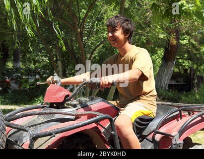 Glücklich asiatische junge auf Quad-Bike atv Stockfoto