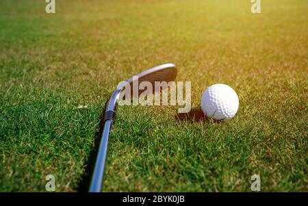 Bereit für Golf in der ersten Short. Golfschläger und Golfbälle auf einer grünen Wiese in einem schönen Golfplatz Stockfoto