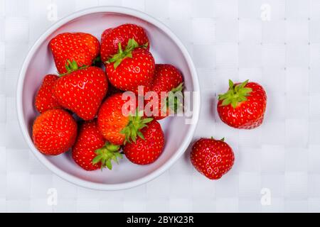 Eine Schüssel mit frischen Erdbeeren auf weißer Tischdecke Stockfoto