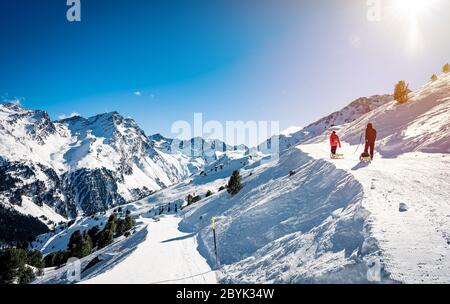 Erfahrener Mann Wanderer Wanderlust während Sonnenuntergang. Stehen gegen erstaunliche hohe Winterberge. Rückansicht von touristischen Reisen in den schönen Alpen Stockfoto