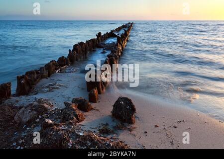 Altes hölzerner Wellenbrecher in der Nordsee bei Sonnenuntergang Stockfoto