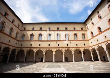 Mailand. Italien - 21. Mai 2019: Hof des Castello Sforzesco. Beige gelbe Wände mit gewölbten Fenstern und Säulen. Stockfoto