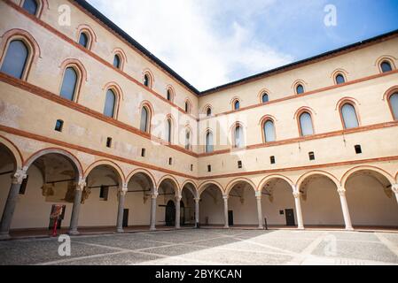 Mailand. Italien - 21. Mai 2019: Hof des Castello Sforzesco. Beige gelbe Wände mit gewölbten Fenstern und Säulen. Stockfoto