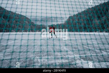 Eishockey-Training. Gekreuzte Hockey Netze im Tornetz mit Eis. Gefrorener Teich Spielplatz im Hintergrund im Hintergrund. Stockfoto