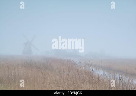 Niederländische Windmühle im dichten Nebel Stockfoto