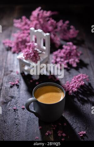 Espresso auf einem Holztisch mit Blumen.aromatischer Kaffee zum Frühstück.gesundes Essen und Trinken. Stockfoto