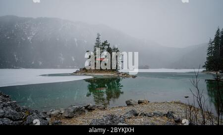 Schöner Wintertag am Eibsee bei grainau an der zugspitze, Spiegelung der Insel Braxeninsel im Winter Stockfoto