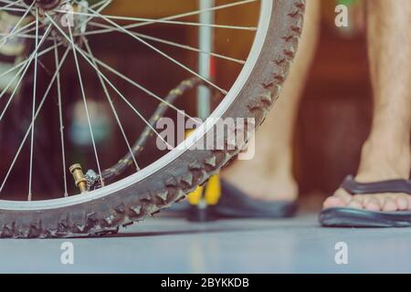 Nahaufnahme von einem jungen Mann, das Pumpen des alten Fahrrad Rad in seinem Haus vorbereiten. . Stockfoto