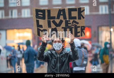 ENSCHEDE, NIEDERLANDE - 05. JUNI 2020: Demonstranten demonstrieren im strömenden Regen im Zentrum von Enschede, um gegen die Tötung o zu protestieren Stockfoto