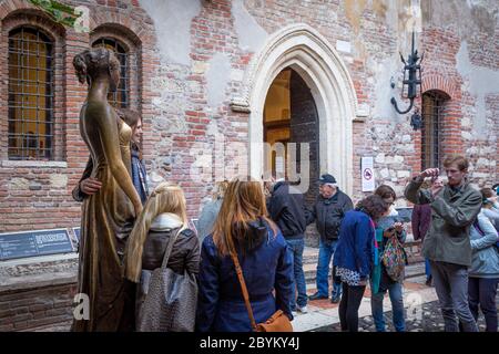 Touristen posieren mit Bronzestatue von Giullieta (von Romeo und Julia Ruhm), Cassa Giullieta, Verona, Venetien, Italien Stockfoto