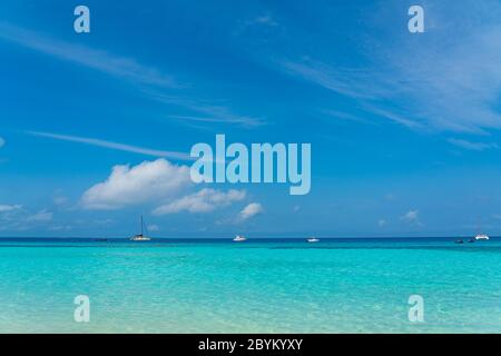 Boote auf türkisfarbenem Ozean mit weißem Sand Blue Sky auf Sansibar Island, Tansania Stockfoto